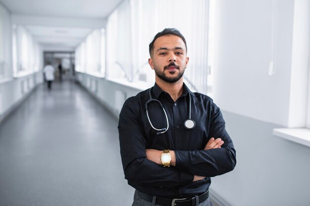 Portret van een jonge dokter die in de gang van de kliniek staat