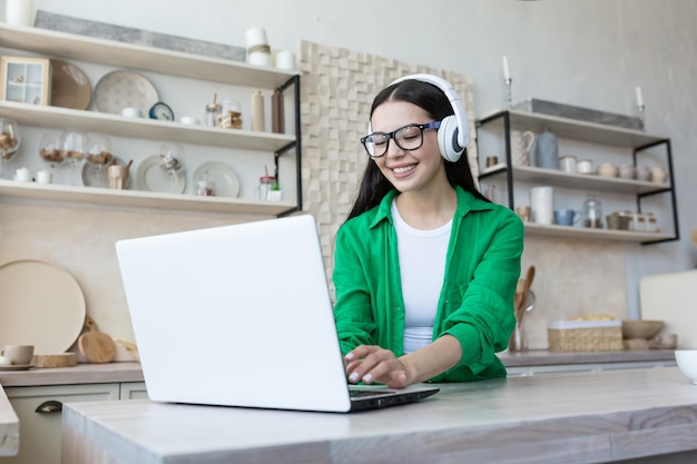 Portret van een jonge duizendjarige studente die thuis online studeert met behulp van een laptop met