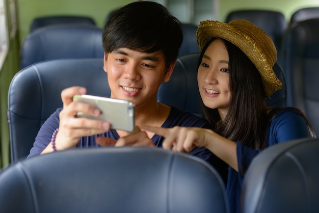 Portret van een jonge filipijnse toeristenman en jonge aziatische toeristenvrouw samen en verliefd bij het treinstation van hua lamphong