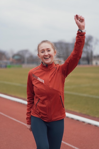 Portret van een jonge fitnessvrouw die loopt in een atletiekstadion