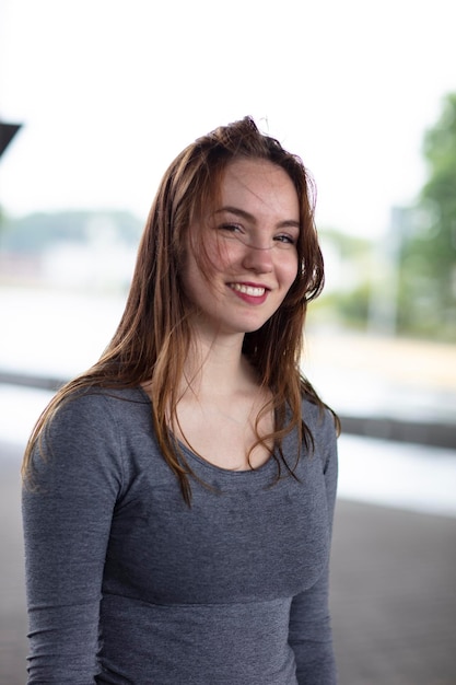 Foto portret van een jonge glimlachende vrouw die buiten staat