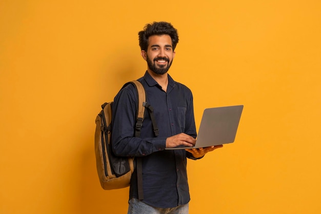 Portret van een jonge Indiase mannelijke student met rugzak en laptop.