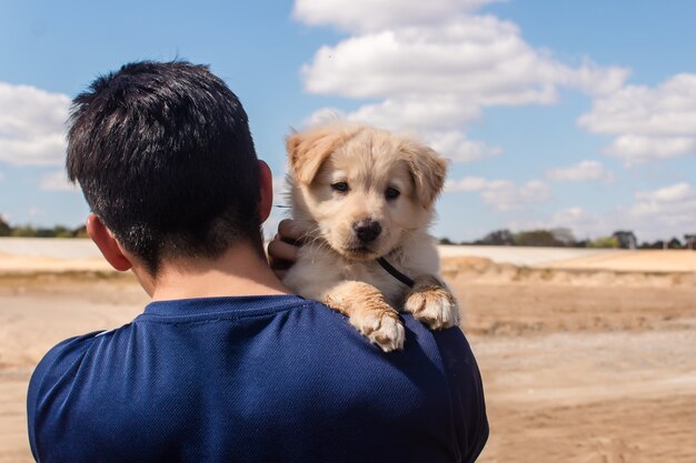 Portret van een jonge jongen die zijn hondje draagt.