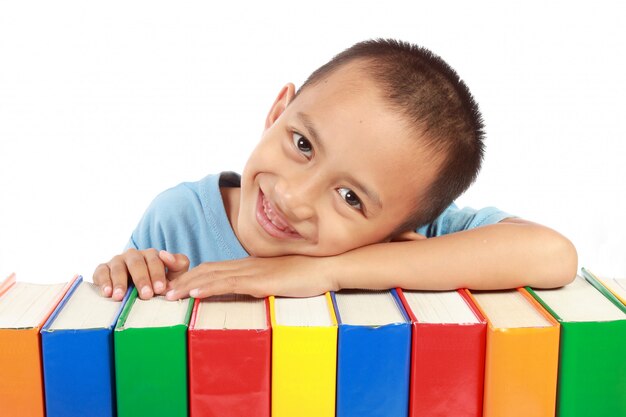 Portret van een jonge jongen leunend op de top van zijn kleurrijke boeken