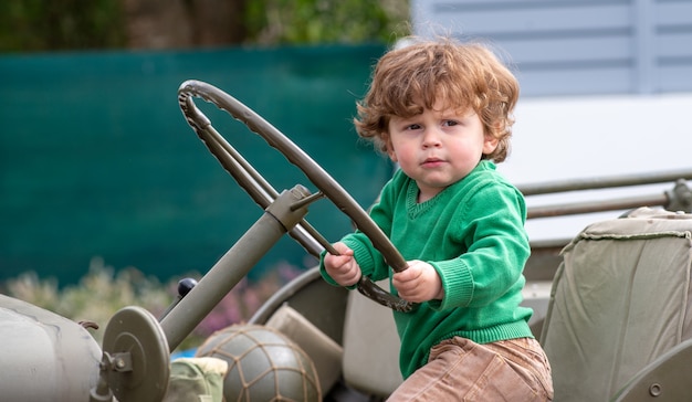 Portret van een jonge jongen met groene trui buiten spelen