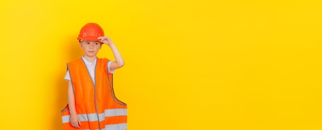 portret van een jonge, knappe arbeider of ingenieur die een helm en een oranje reflecterend vest draagt