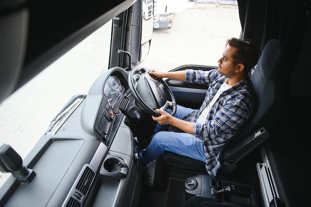 Portret van een jonge knappe Indiase vrachtwagenchauffeur Het concept van logistiek en vrachtvervoer