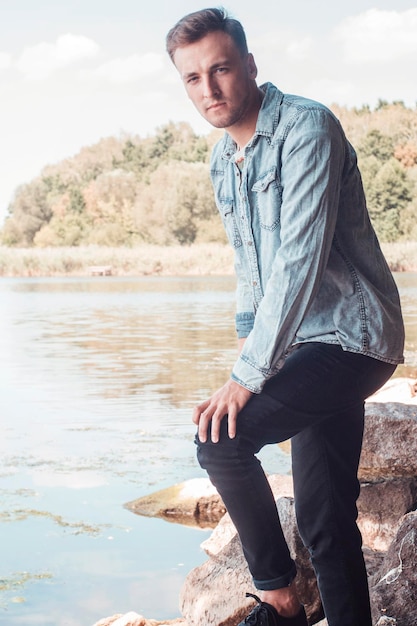 Portret van een jonge knappe jongen in de buurt van de rivier.