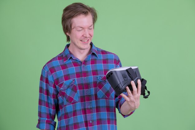 Portret van een jonge knappe scandinavische hipster man tegen chromakey of groene muur