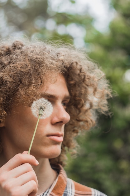 Portret van een jonge krullende haired kerel in een de zomerpark