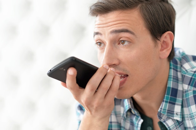 Portret van een jonge man die aan de telefoon spreekt