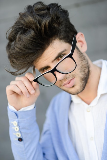 Portret van een jonge man die een bril draagt terwijl hij buiten staat