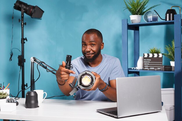 Portret van een jonge man die een mobiele telefoon gebruikt terwijl hij op tafel zit