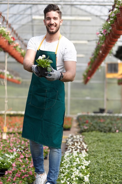 Portret van een jonge man die in een kas staat