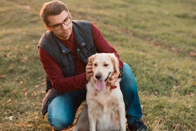 Foto portret van een jonge man die knuffelt met een golden retriever man speelt met een hond