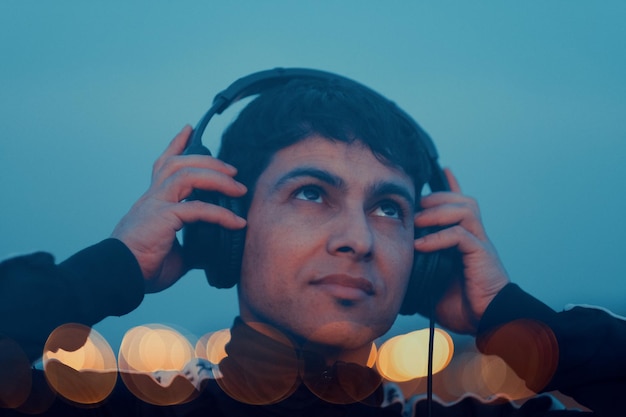 Portret van een jonge man die naar muziek luistert met koptelefoon