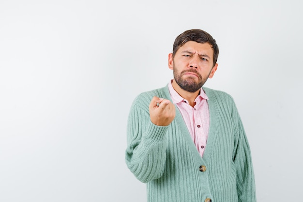 Portret van een jonge man die naar voren wijst in hemd, vest en aarzelend vooraanzicht kijkt