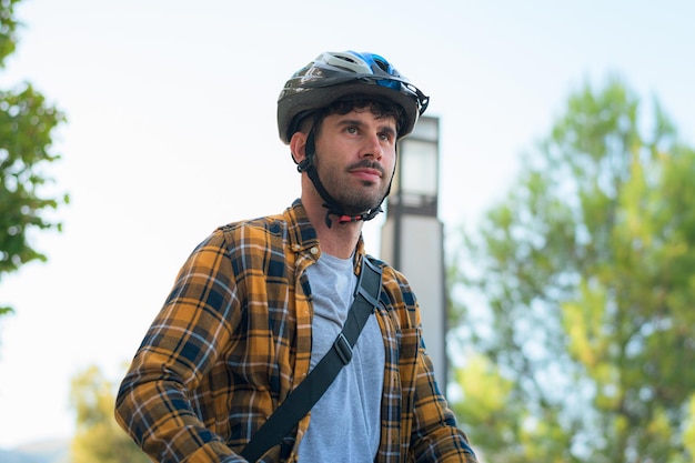 Portret van een jonge man die op een elektrische scooter rijdt met een helm