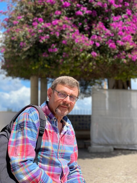 Foto portret van een jonge man die tegen bomen staat