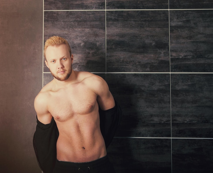 Foto portret van een jonge man die tegen de muur staat