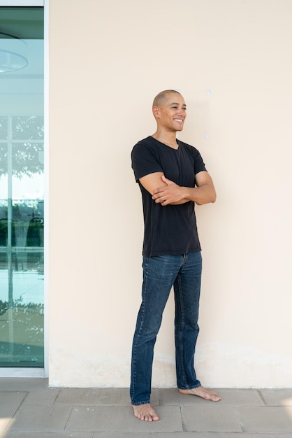 Portret van een jonge man die tegen de muur staat