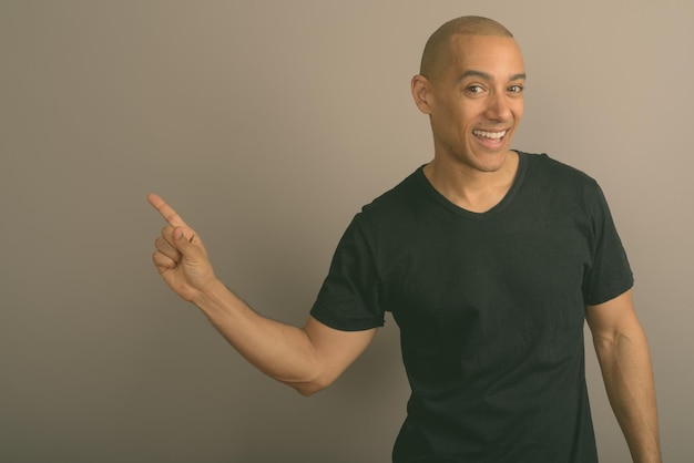 Portret van een jonge man die tegen de muur staat