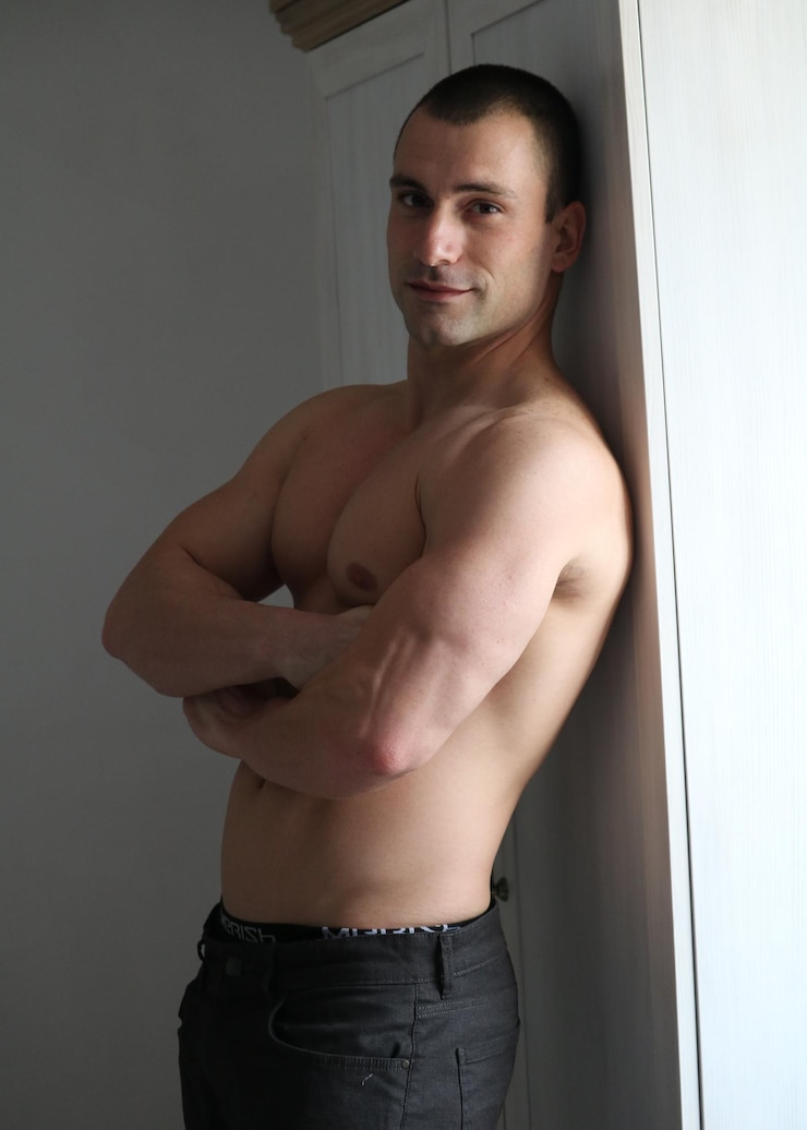 Foto portret van een jonge man die tegen de muur staat