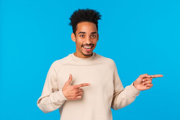 Foto portret van een jonge man die tegen een blauwe achtergrond staat