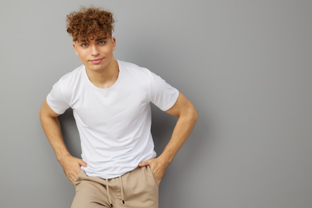 Foto portret van een jonge man die tegen een grijze achtergrond staat