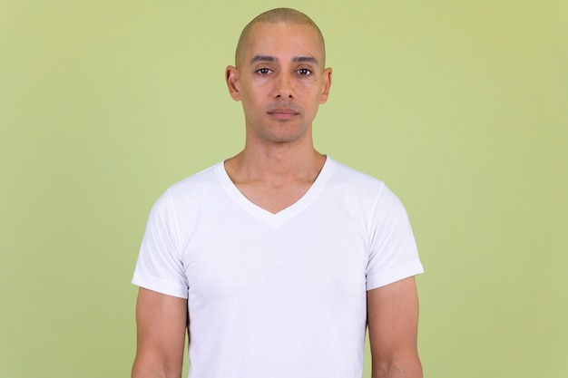 Portret van een jonge man die tegen een grijze achtergrond staat