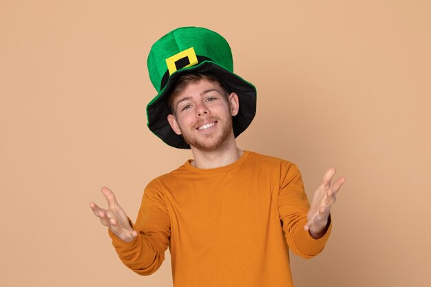 Foto portret van een jonge man die tegen een oranje achtergrond staat