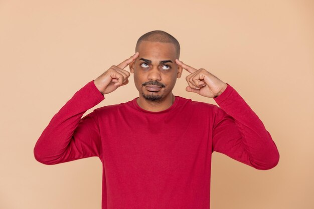 Foto portret van een jonge man die tegen een rode achtergrond staat