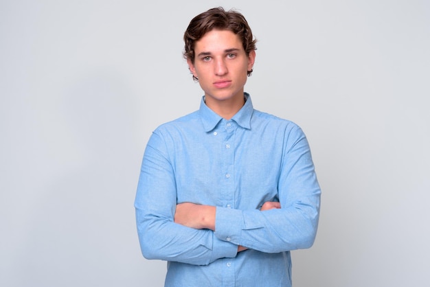 Portret van een jonge man die tegen een witte achtergrond staat