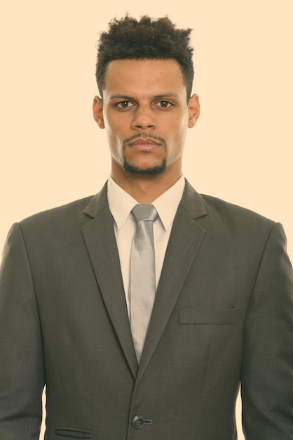Portret van een jonge man die tegen een witte achtergrond staat