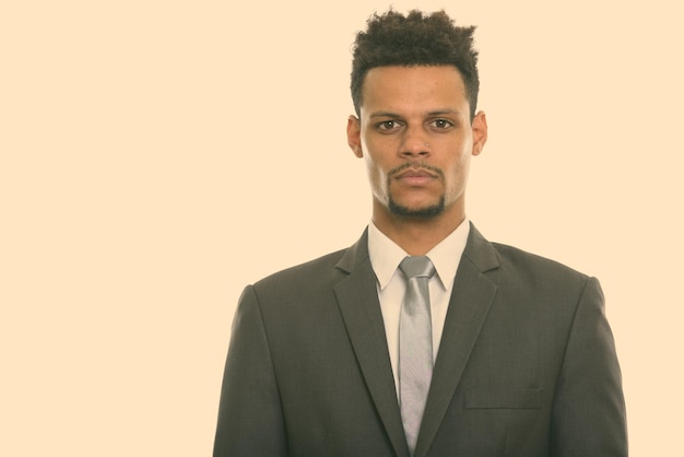 Portret van een jonge man die tegen een witte achtergrond staat