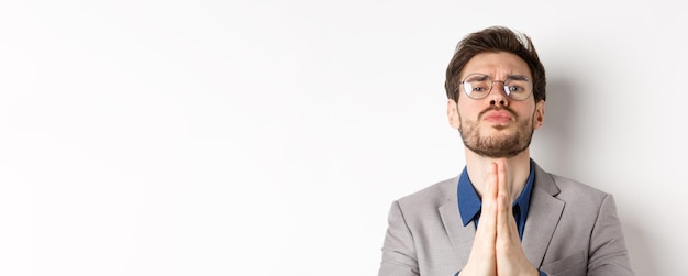 Portret van een jonge man die tegen een witte achtergrond staat