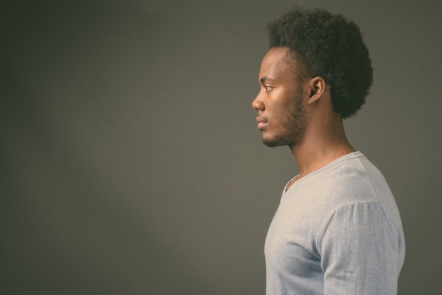 Portret van een jonge man die tegen een witte achtergrond wegkijkt