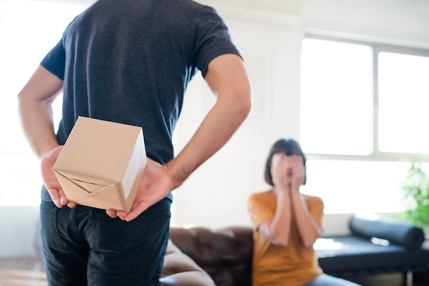 Portret van een jonge man die zijn vriendin verrast met een cadeautje