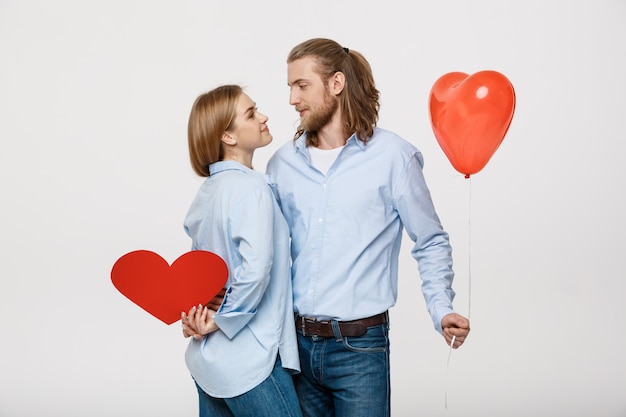 Portret van een jonge man en vrouw met een hartvormige ballon en papier
