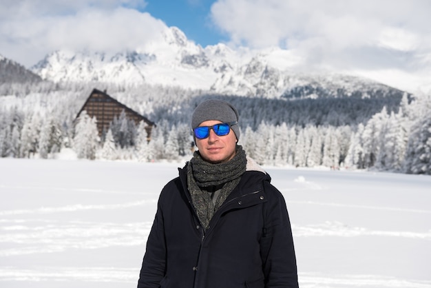 Portret van een jonge man in de winter bergen. Recreatie en gezonde levensstijl buiten in de besneeuwde natuur