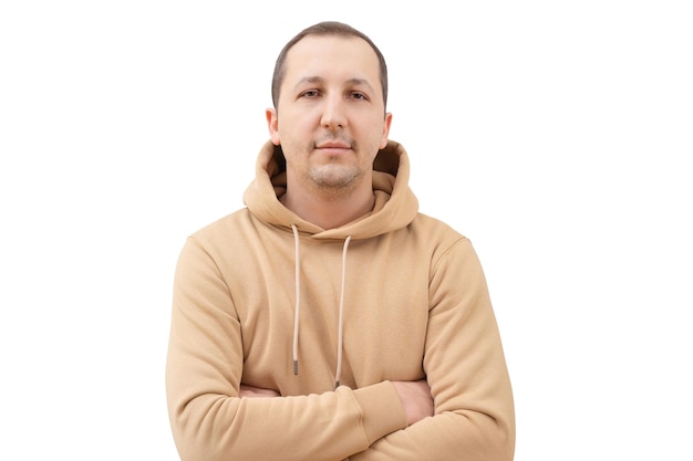 Foto portret van een jonge man in een beige sweatshirt die naar de camera kijkt op een witte achtergrond