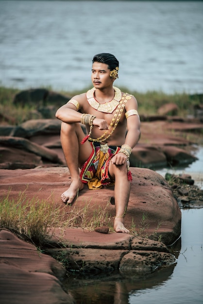 Portret van een jonge man in klederdracht poseren in de natuur in Thailand