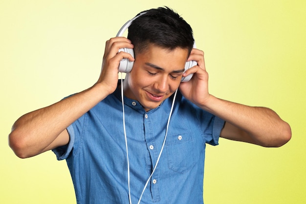 Portret van een jonge man, luisteren naar muziek met een koptelefoon