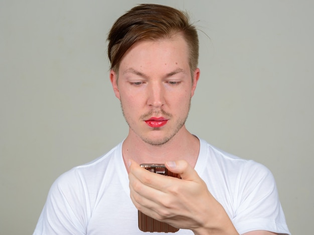 Portret van een jonge man met baard stoppels make-up dragen