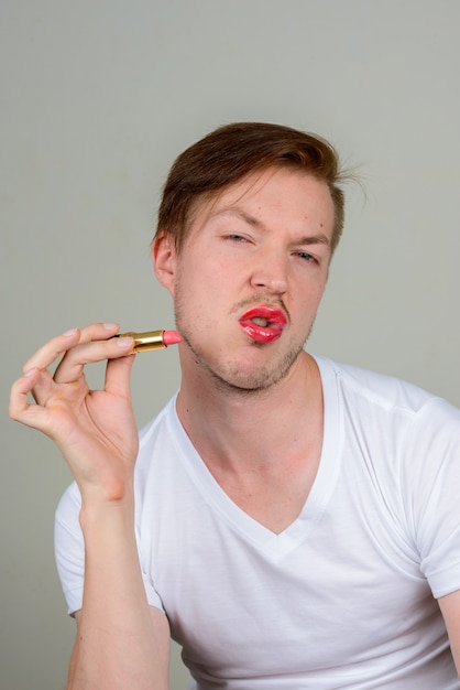 Portret van een jonge man met baard stoppels make-up dragen