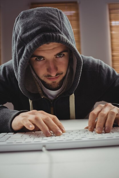 Portret van een jonge man met behulp van computertoetsenbord