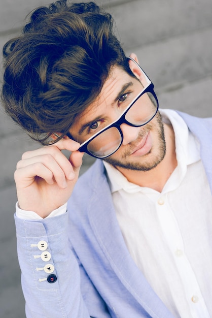 Portret van een jonge man met een bril terwijl hij buiten staat