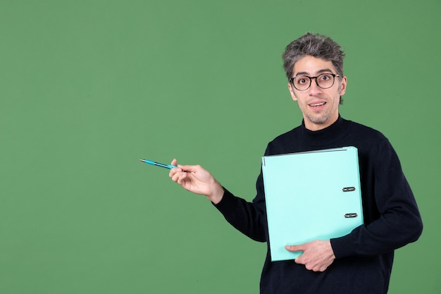 portret van een jonge man met een groen document op een groene achtergrond, werk zakelijk leraar