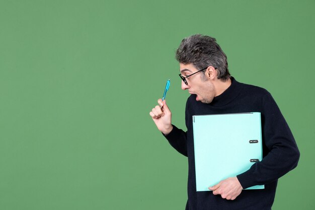 portret van een jonge man met een groen document op een groene achtergrond zakelijke baan lesleraren