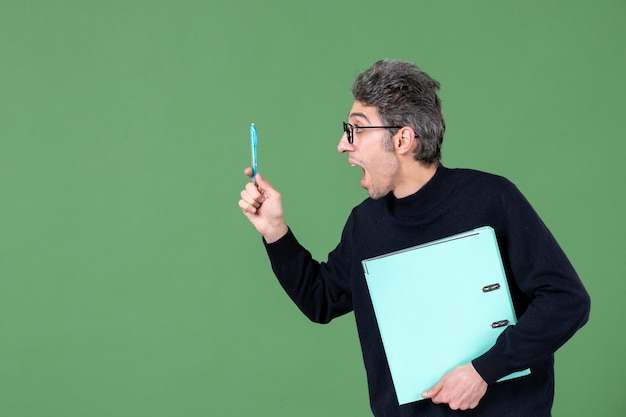 portret van een jonge man met een groen document op een groene achtergrond zakelijke les